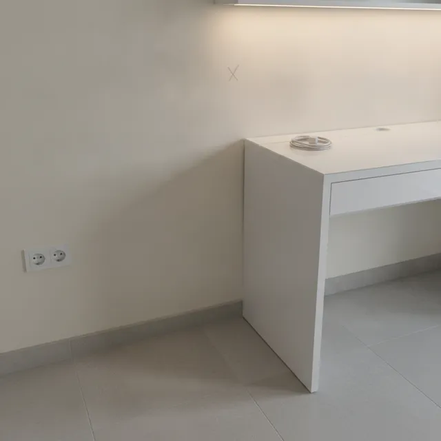 Wall by a desk marked for a new socket